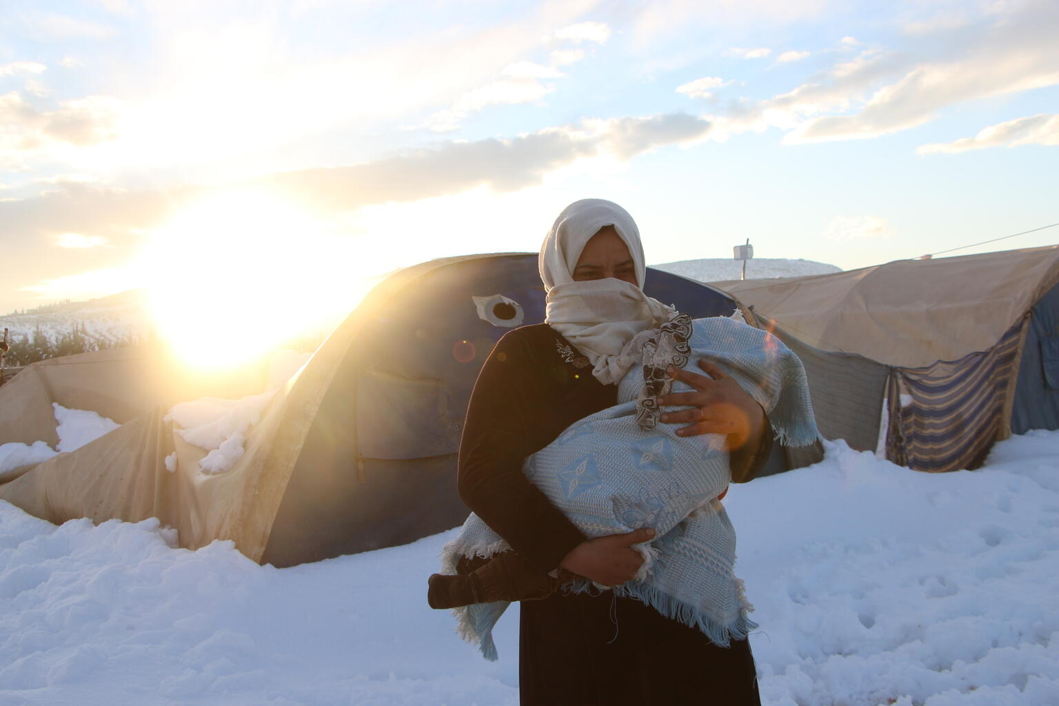 On 19 January 2022 at an Internally Displaced Person (IDP) camp in Northwest Syria, a mother carries her child fearing for their lives as temperatures drop.